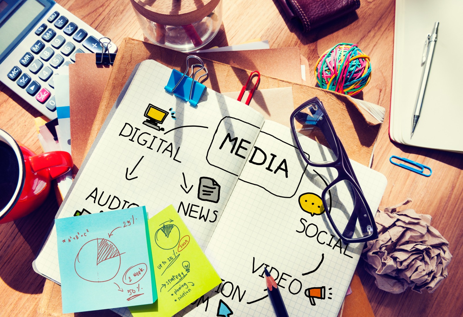 A small business owner's desk is covered with items from their PR checklist